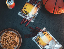 Beef stick, jerky, pretzels in bowl, basketball and soda can