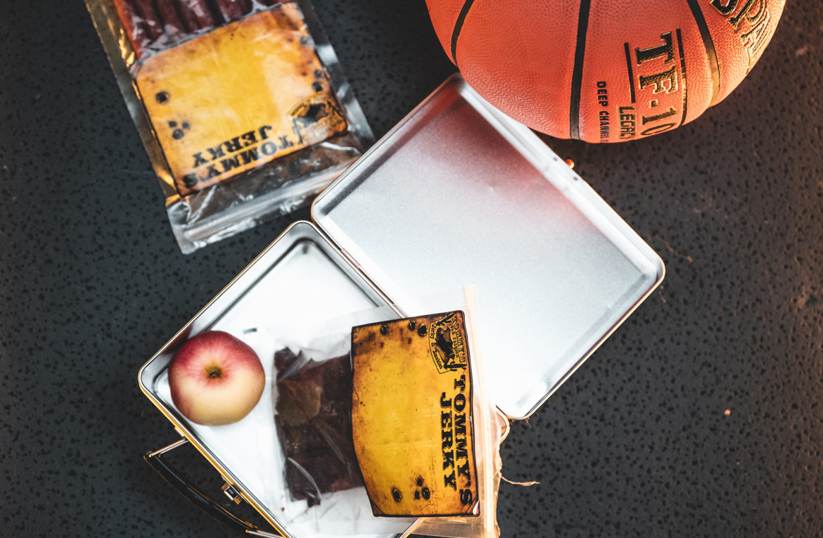 Jerky and apple in tin box with basketball in back