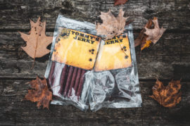 Beef stick and jerky on wooden table with leaves