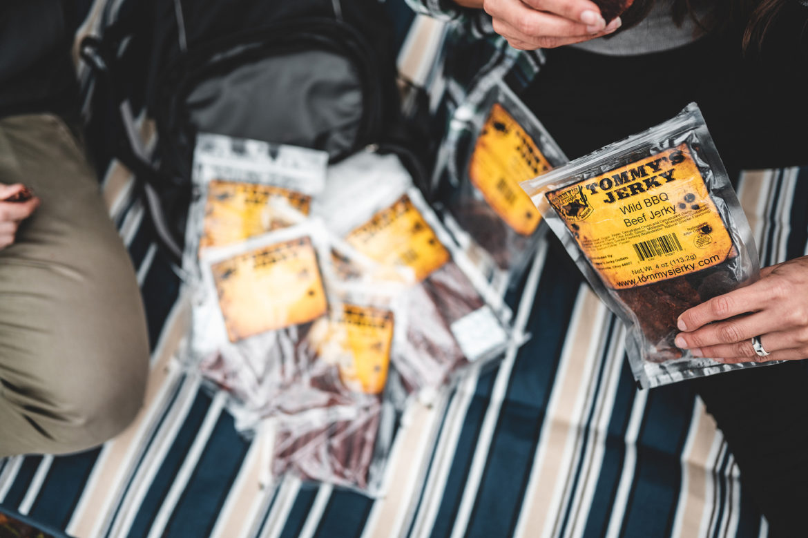 Jerky in hand on striped background